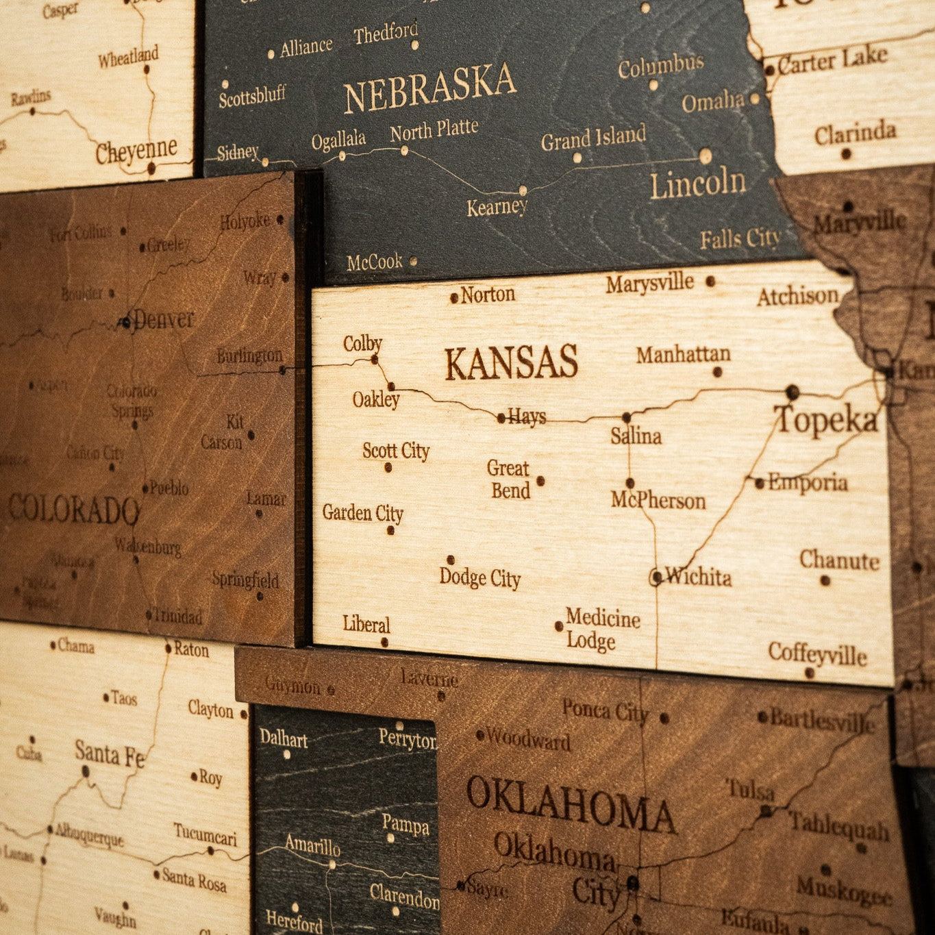 Wooden maps of Nebraska, Kansas, and Oklahoma with city names.