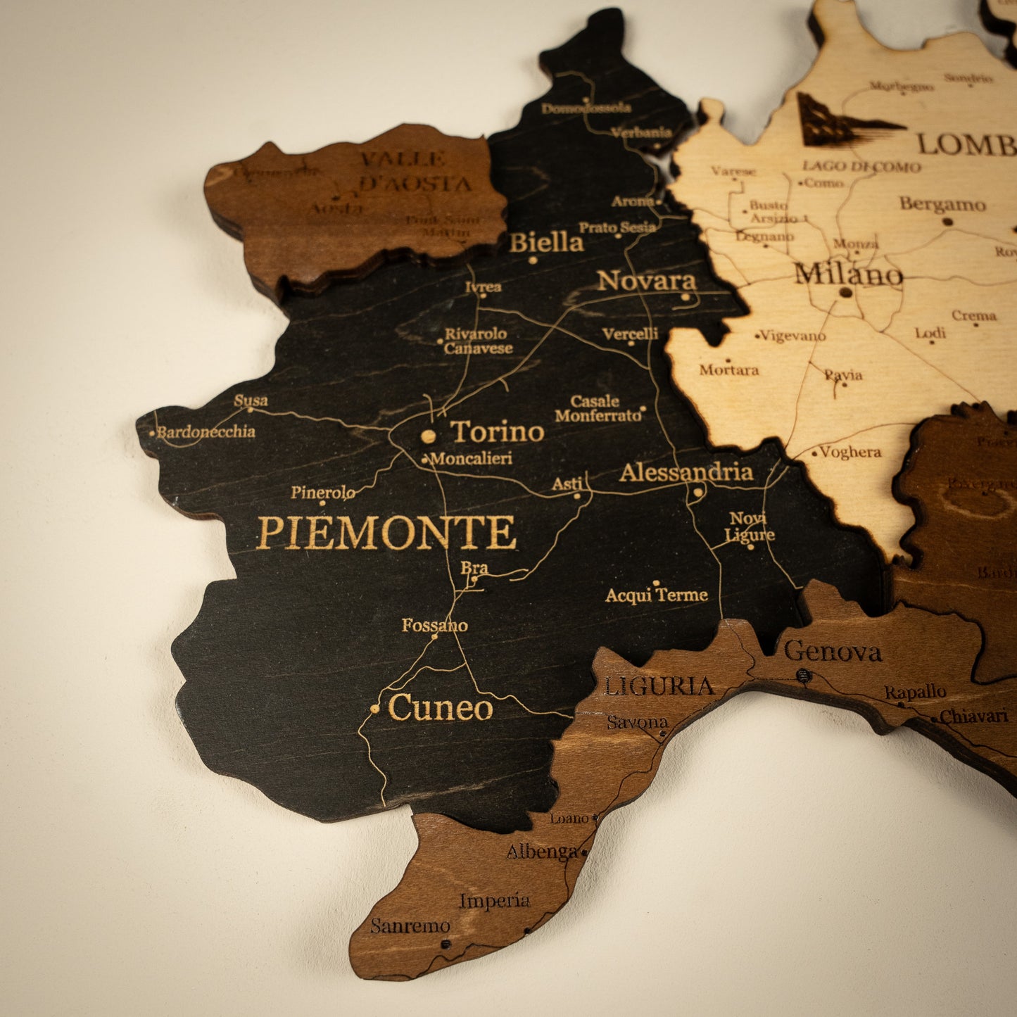 Wooden map of Piemonte with cities labeled on a beige background
