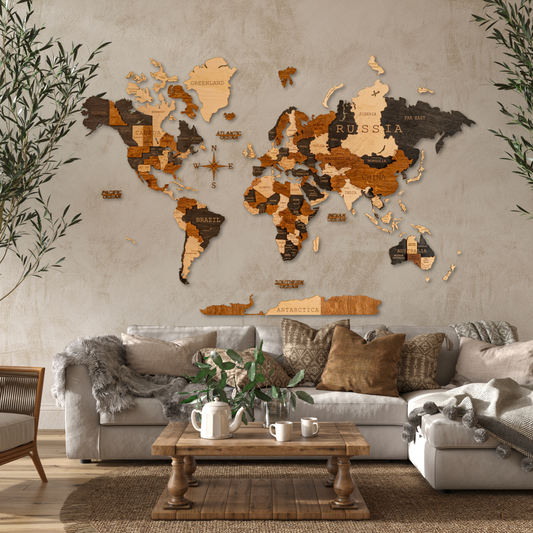 A 3D wooden world map with varying shades of brown and black, mounted on a wall above a beige sofa with cushions. The map features detailed country outlines and is displayed in a room with a concrete wall and indoor plants.